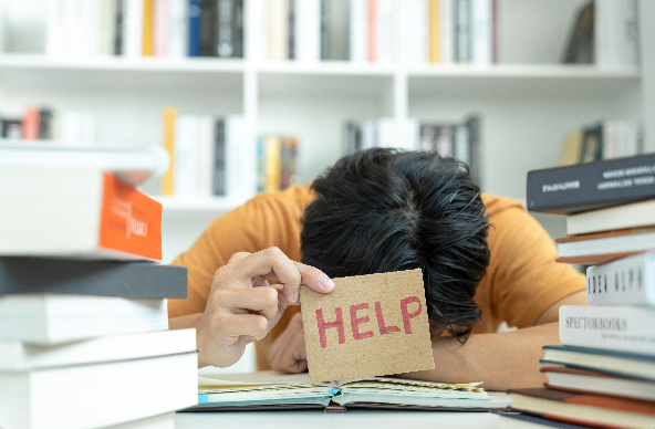 Person holding a little note saying HELP and hiding their face