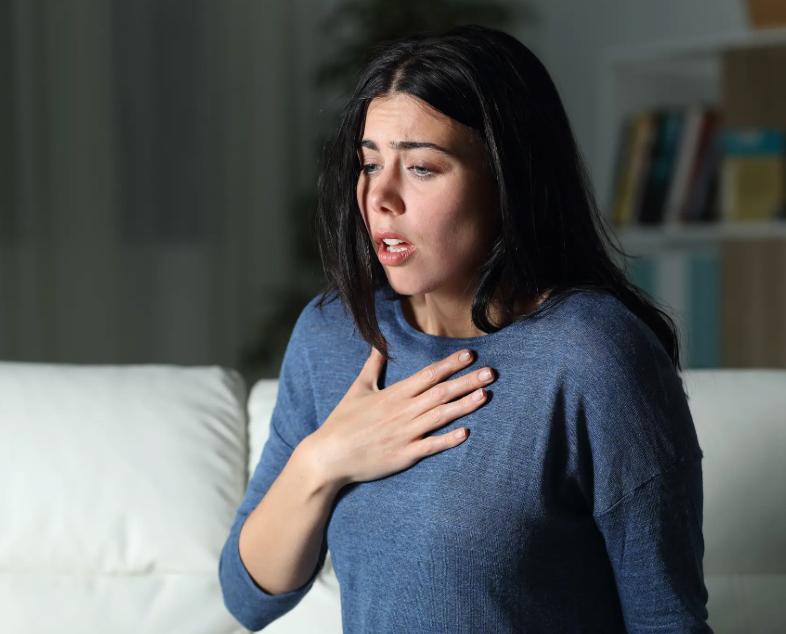 Woman touching her chest, trying to breath in